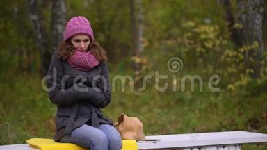 凄美女子冻在秋公园，寒秋.. 她感到寒冷，并试图保暖。 慢动作